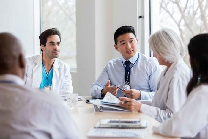 student and doctors talking at a table